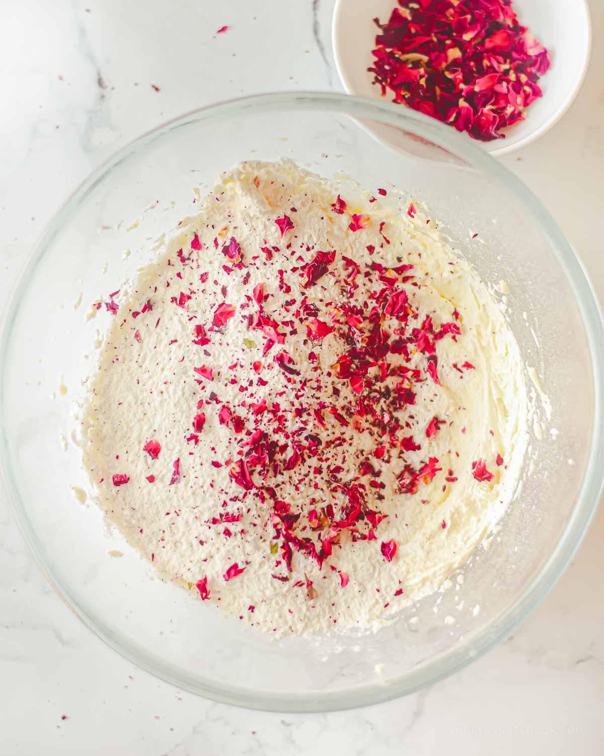 Large bowl with shortbread dough and rose petals sprinkled on top.