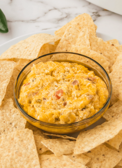 cheesy jalapeño dip in a bowl surrounded by tortilla chips