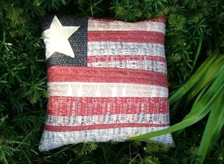 quilted flag pillow with white and red stripes and one star.