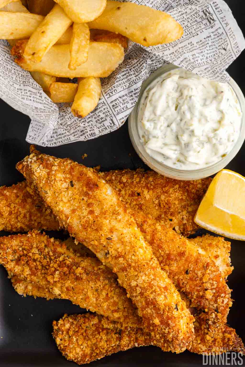 Fried fish in the air fryer on a plate with fries and tartar sauce.