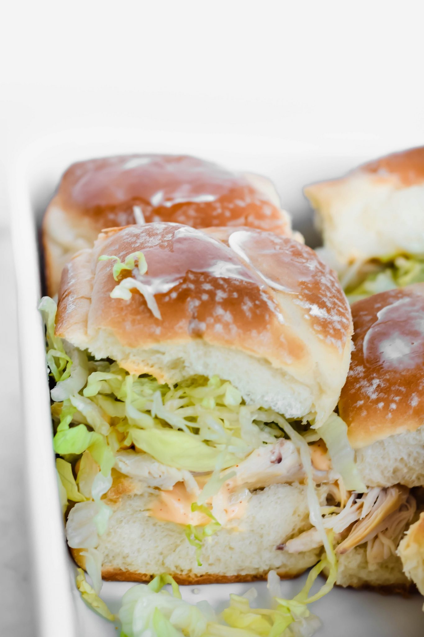 Rotisserie chicken sliders in a baking dish.