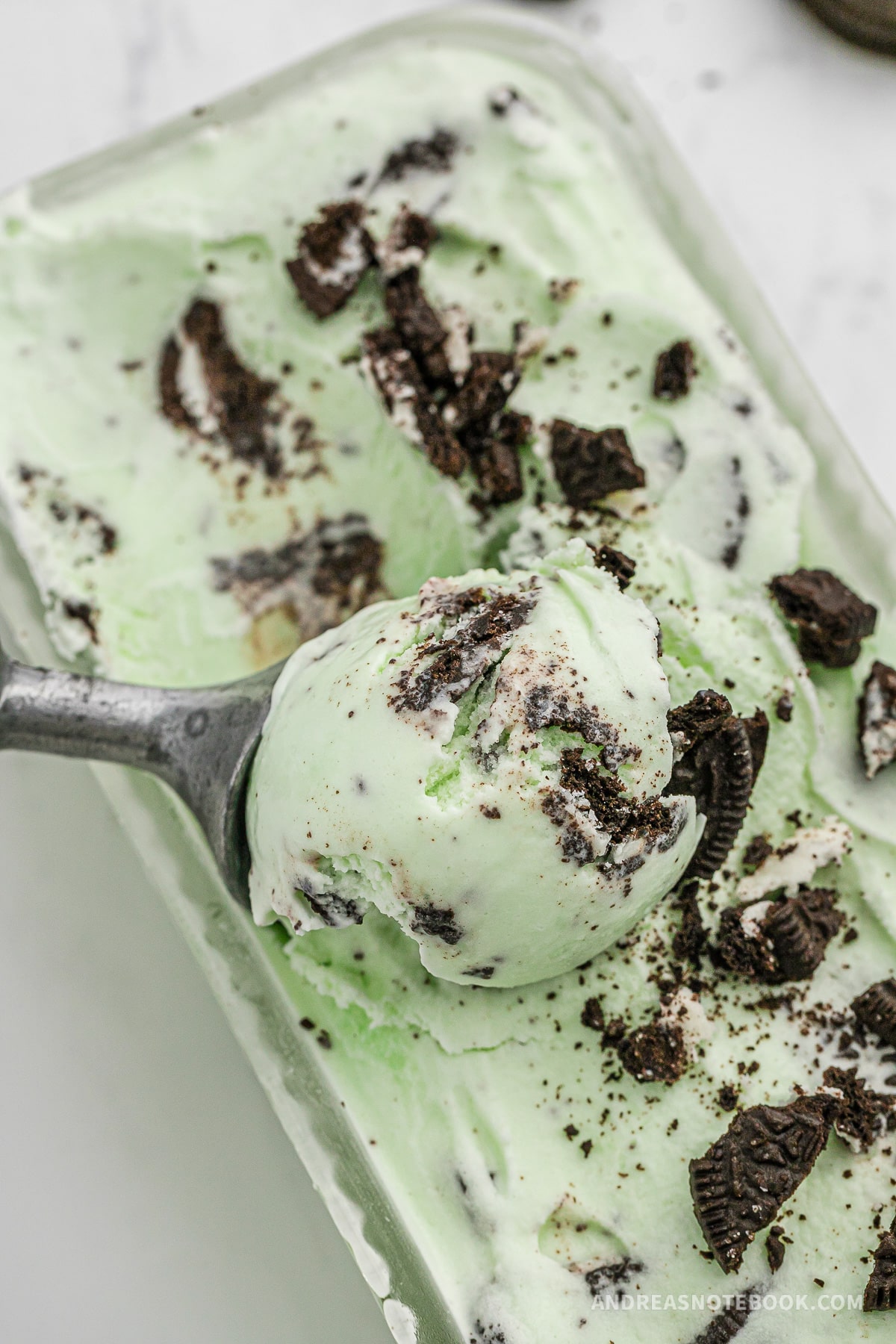 Ice cream scoop scooping out mint cookie ice cream.