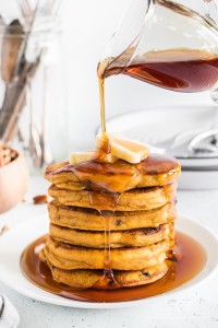 Syrup pouring over pumpkin pecan pancakes.