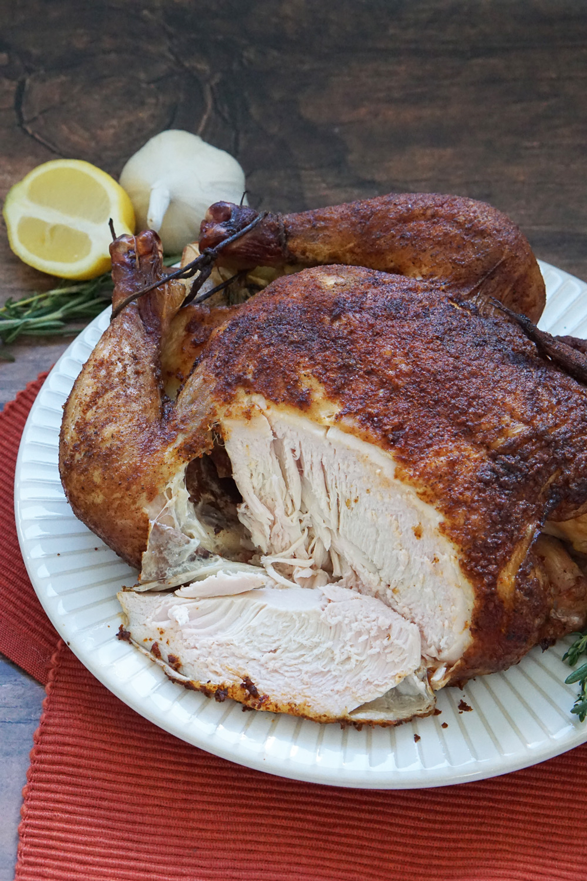 Whole traeger smoked chicken with slice cut out.