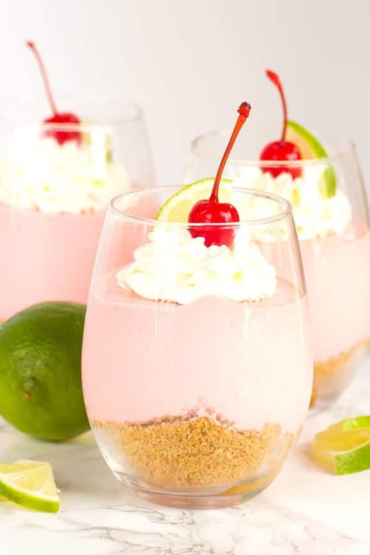 cherry limeade cheesecake parfait in a glass.