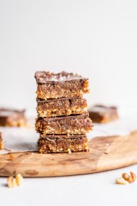 Oats and chocolate caramel bars stacked on top of each other.