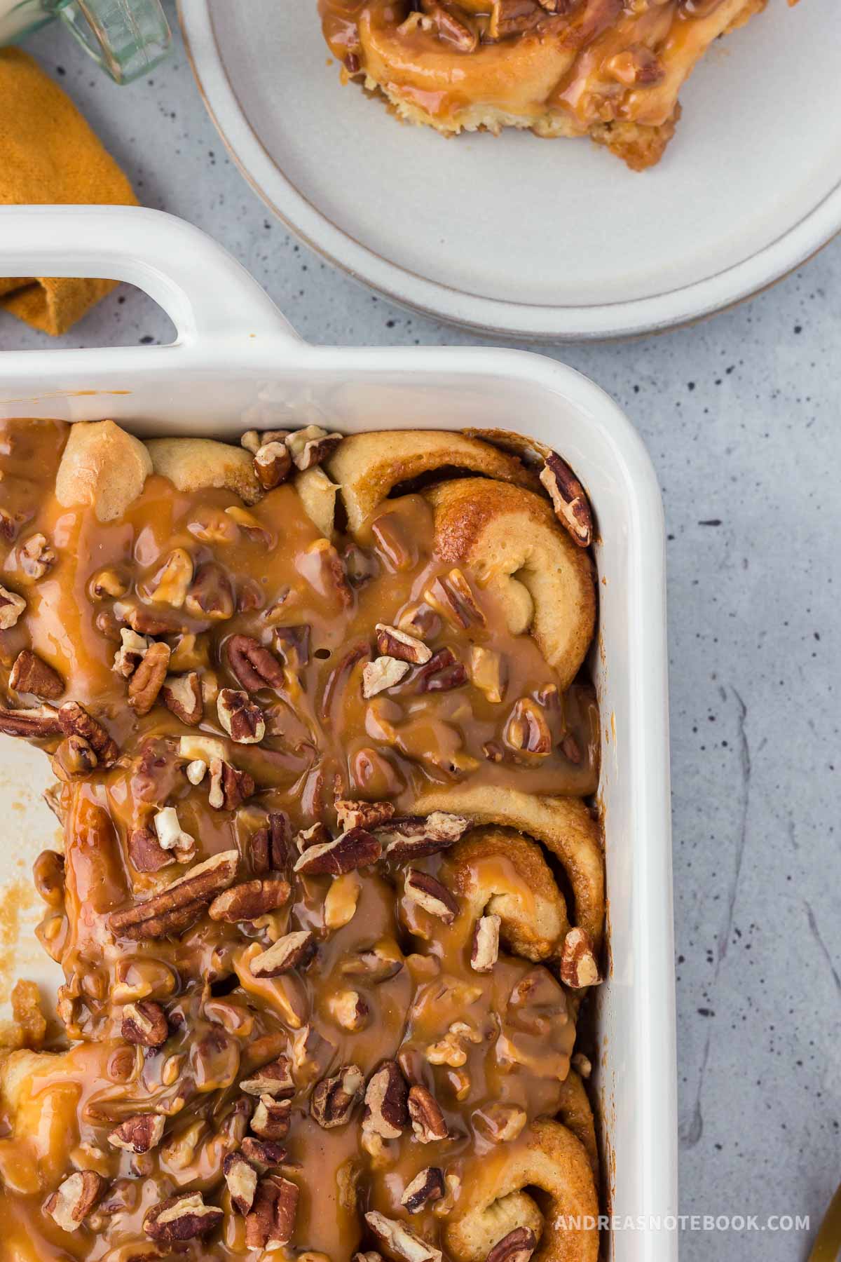 Pan of caramel covered cinnamon rolls in a baking dish.