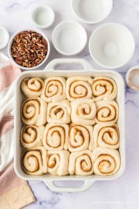 Uncooked cinnamon rolls in a square baking pan.