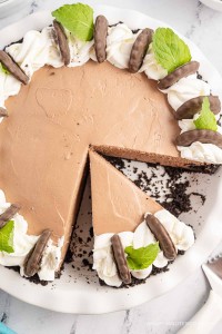 Whole no bake chocolate mint pie with one slice missing.