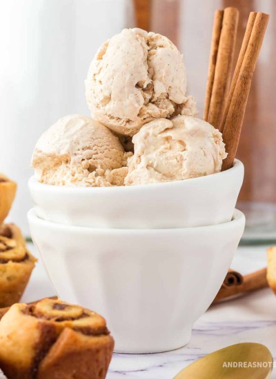 Cinnamon ice cream scoops in a bowl with cinnamon sticks.