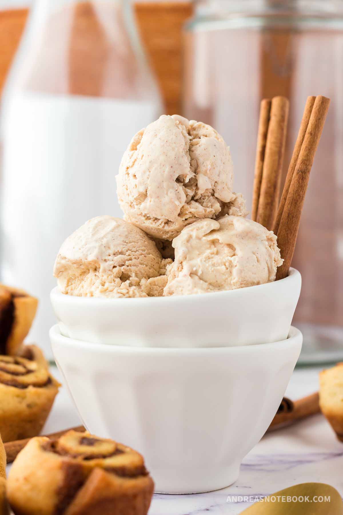 Cinnamon ice cream scoops in a bowl with cinnamon sticks.
