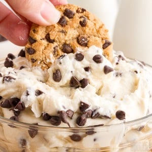 Chocolate chip cookie dough dipping into creamy chocolate chip cookie dip.
