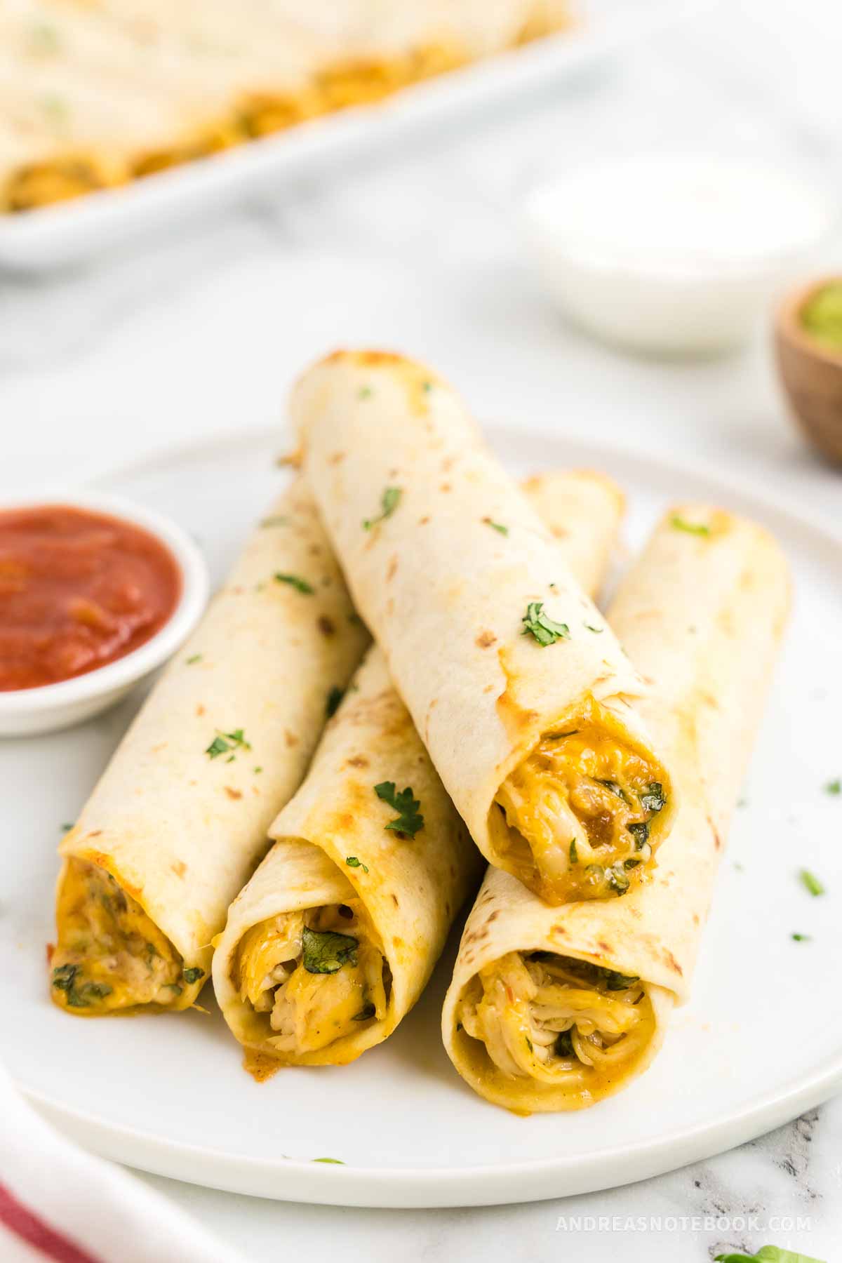 Stack of homemade cheesy chicken taquitos.