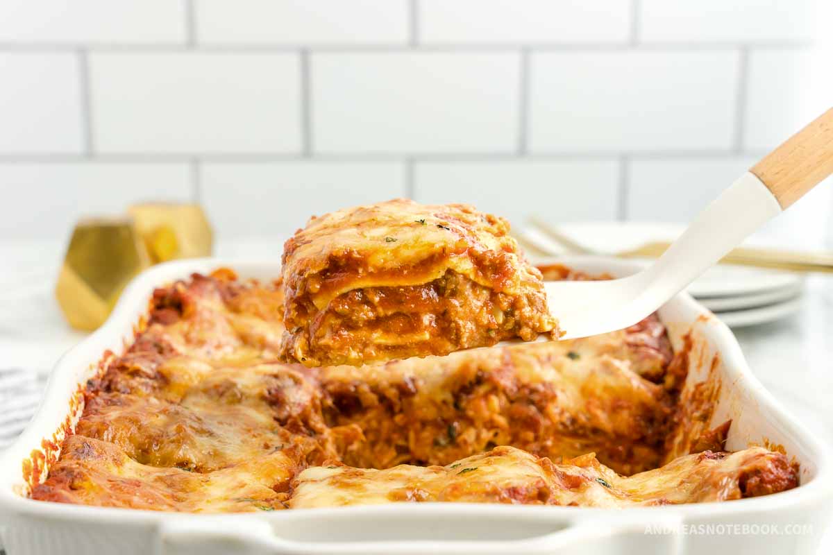 Piece of lasagna being scooped out with a spatula.