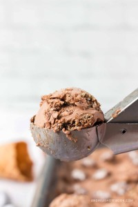 Scoop of chocolate peanut butter ice cream with muddy buddy pieces.