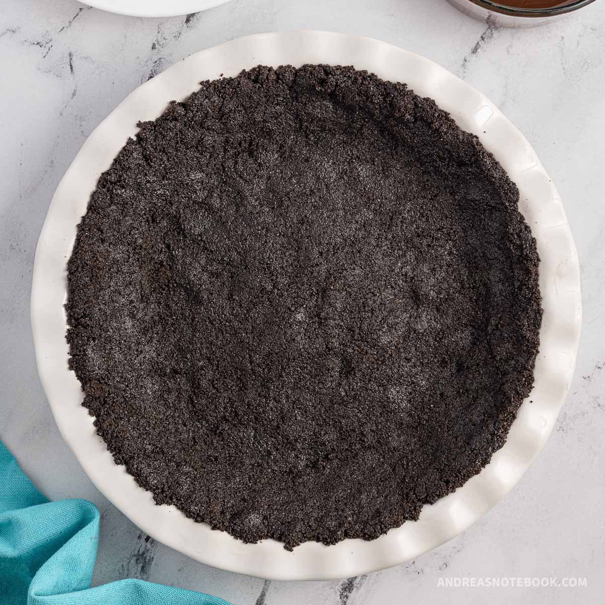 No bake chocolate oreo pie crust in a white pie pan.