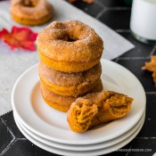 Stack of pumpkin spice donuts on a white plate.
