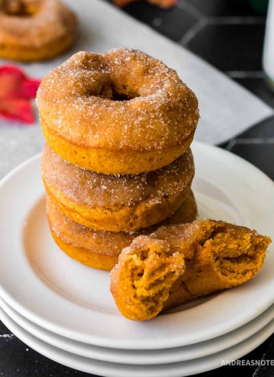 Stack of pumpkin spice donuts on a white plate.