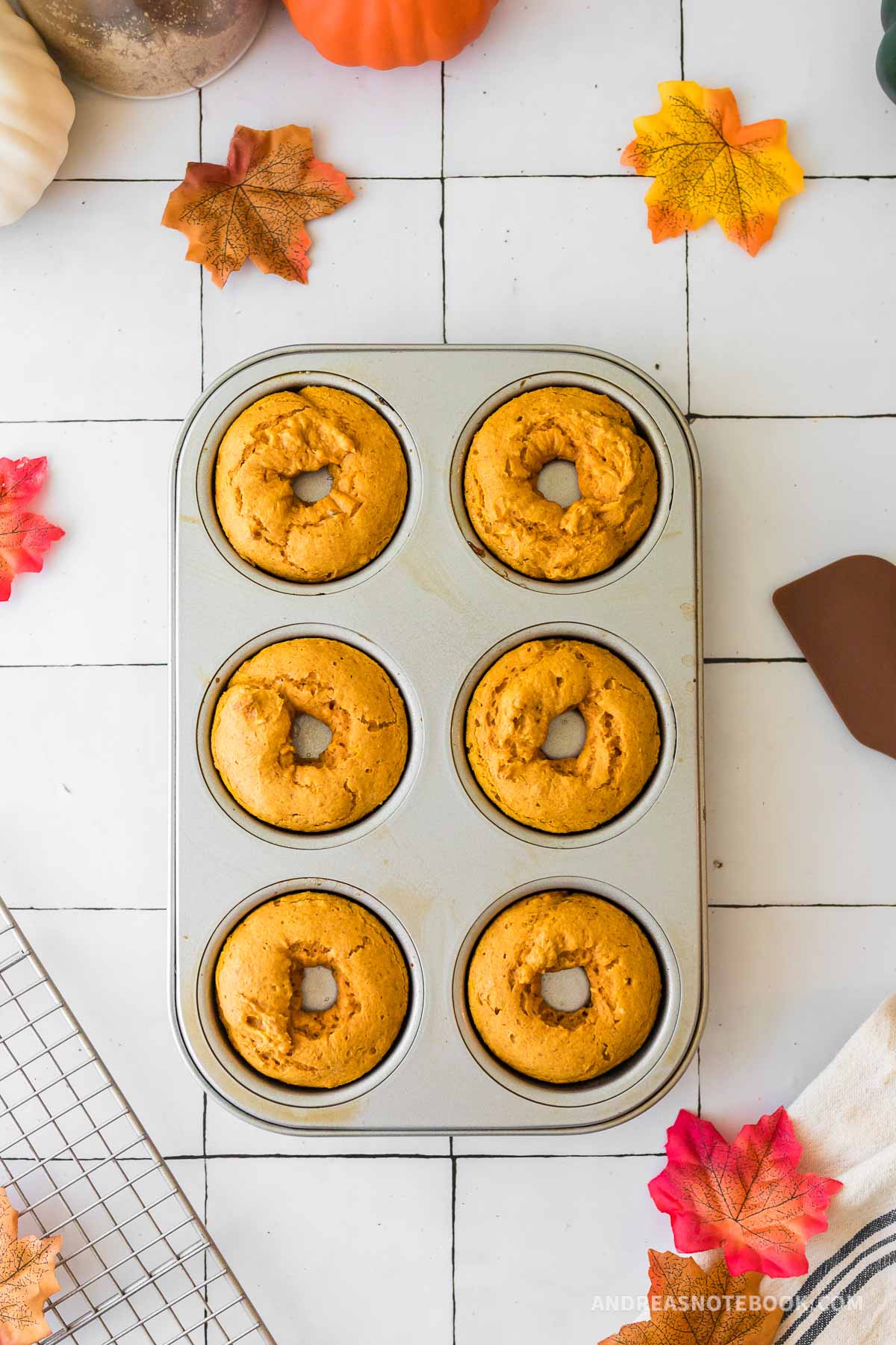 Cooked pumpkin spice donuts in a donut baking pan.