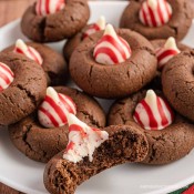 Chocolate candy cane kiss blossom cookies in a pile.