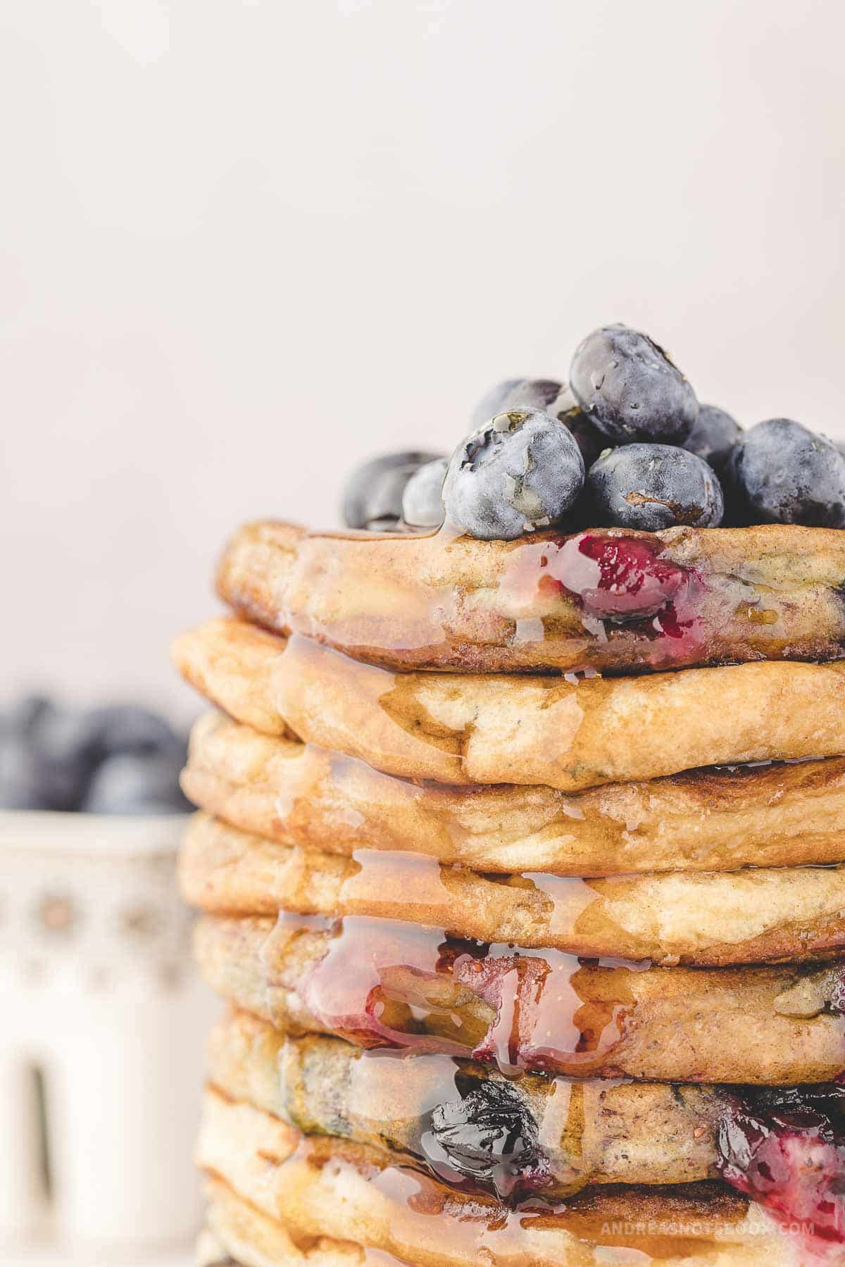Large stack of blueberry pancakes with syrup.