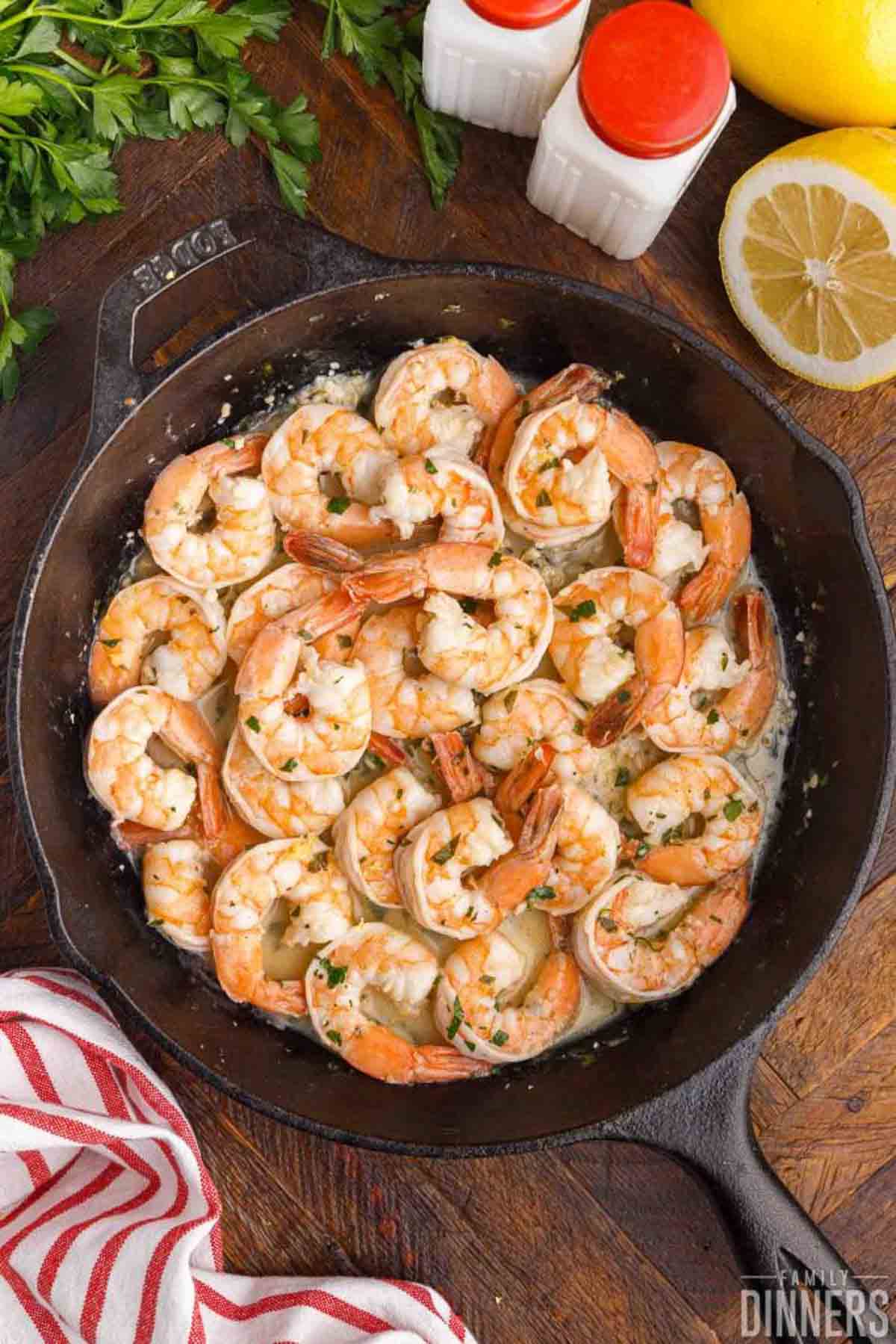 Lemon garlic shrimp cooked in a cast iron skillet until pink and curled.