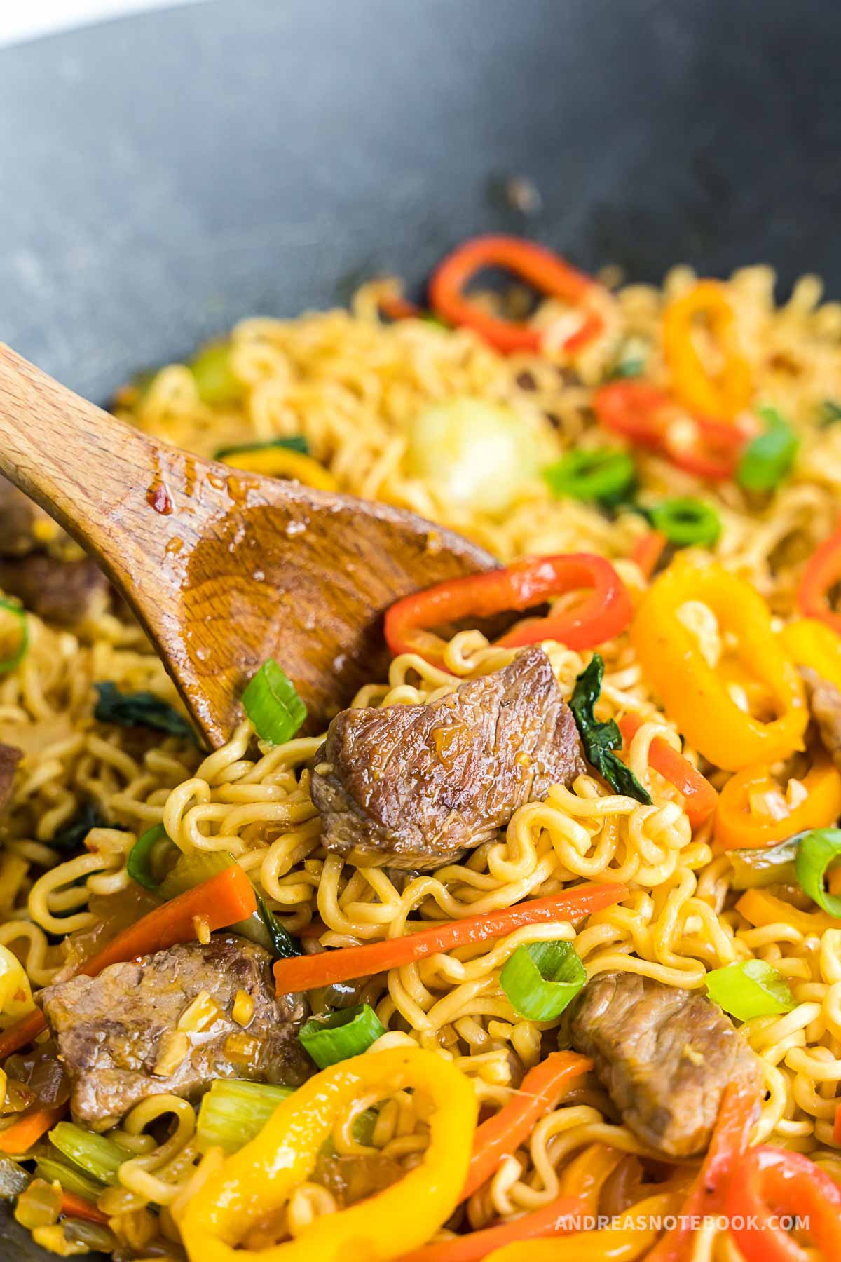 Wok full of spicy beef stir fry with ramen noodles.