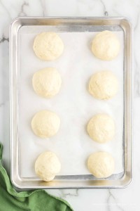 8 balls of dough on a baking sheet.
