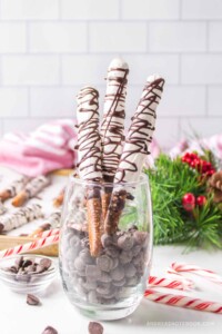 Christmas candy mint chocolate covered pretzel rods in a glass.