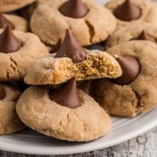 Plate full of peanut butter cookies with hersheys kisses on top.