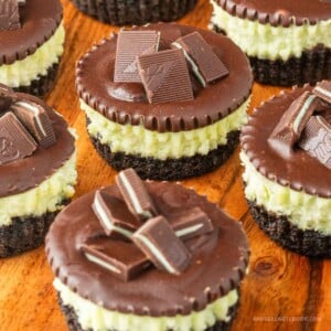 Mini andes mint chocolate cheesecake cupcakes on a wood board.