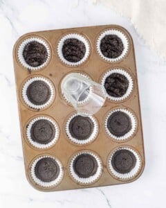 Small class being used to compress oreos in cupcake tin.