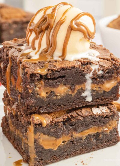 Two biscoff brownies on top of each other with a scoop of vanilla ice cream on top.
