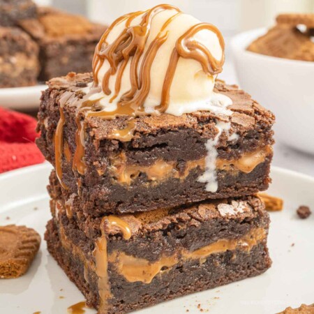 Two biscoff brownies on top of each other with a scoop of vanilla ice cream on top.