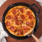 Deep dish pizza in a cast iron pan with pepperoni.