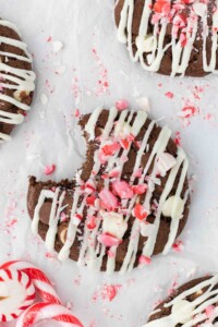 Chocolate chocolate chip cookie with white chocolate drizzle on top and crumbled candy cane.