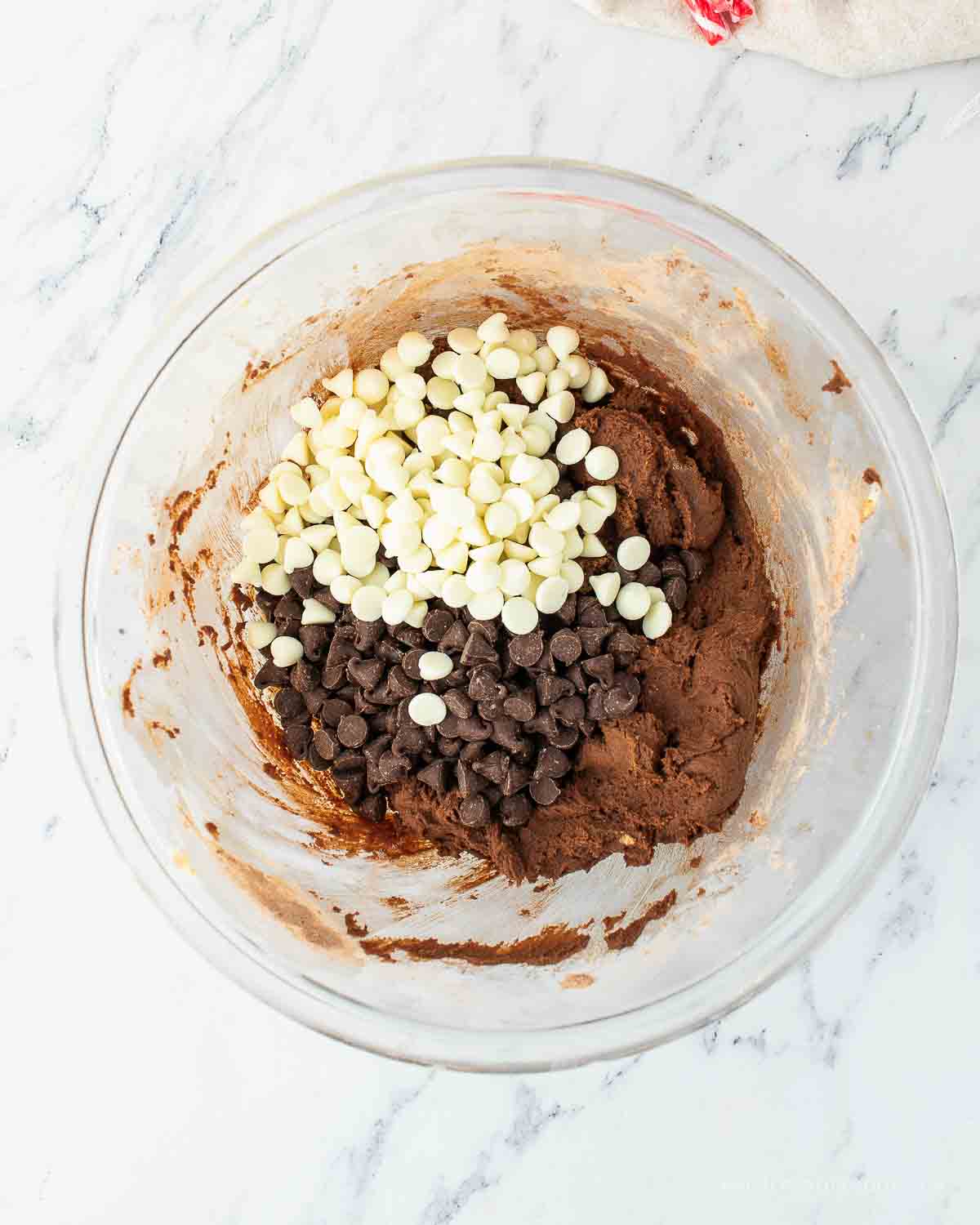 Chocolate chips and white chocolate chips added to chocolate cookie batter.