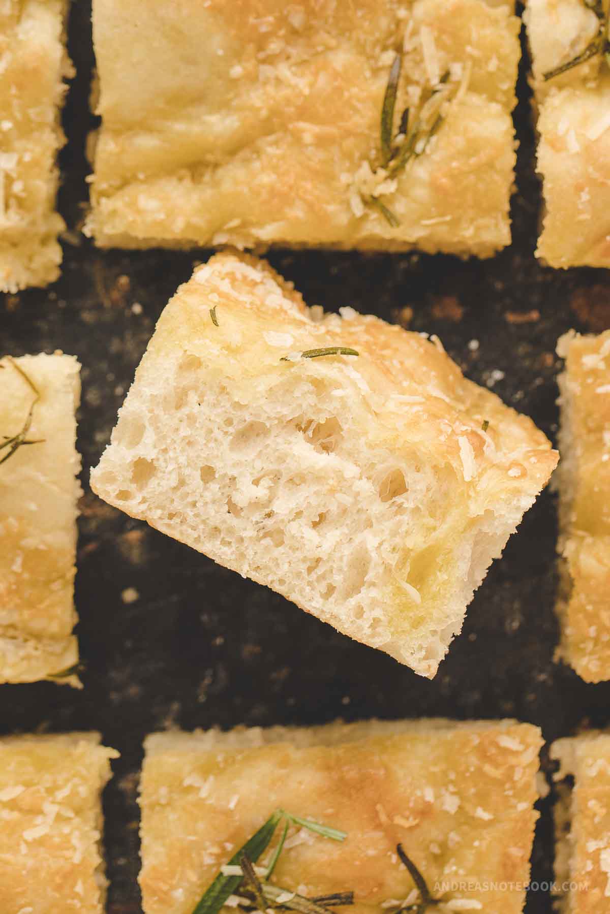 Square of garlic herb focaccia bread on it's side showing light fluffiness.