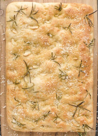 Full loaf of garlic rosemary focaccia bread with parmesan cheese on top.