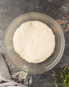 Focaccia bread dough doubled in size in a bowl.