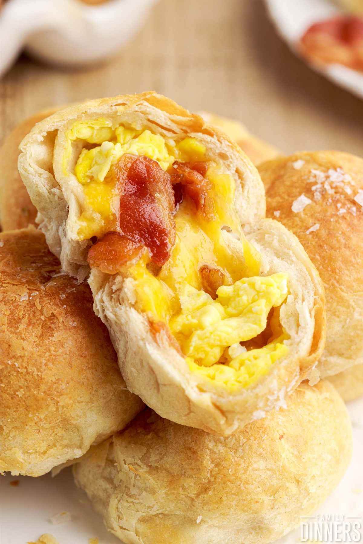 Opened ball of scrambled egg, cheese and bacon surrounded by golden biscuit. 
