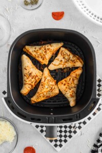 Baked pepperoni hot pockets cooked in the air fryer basket.