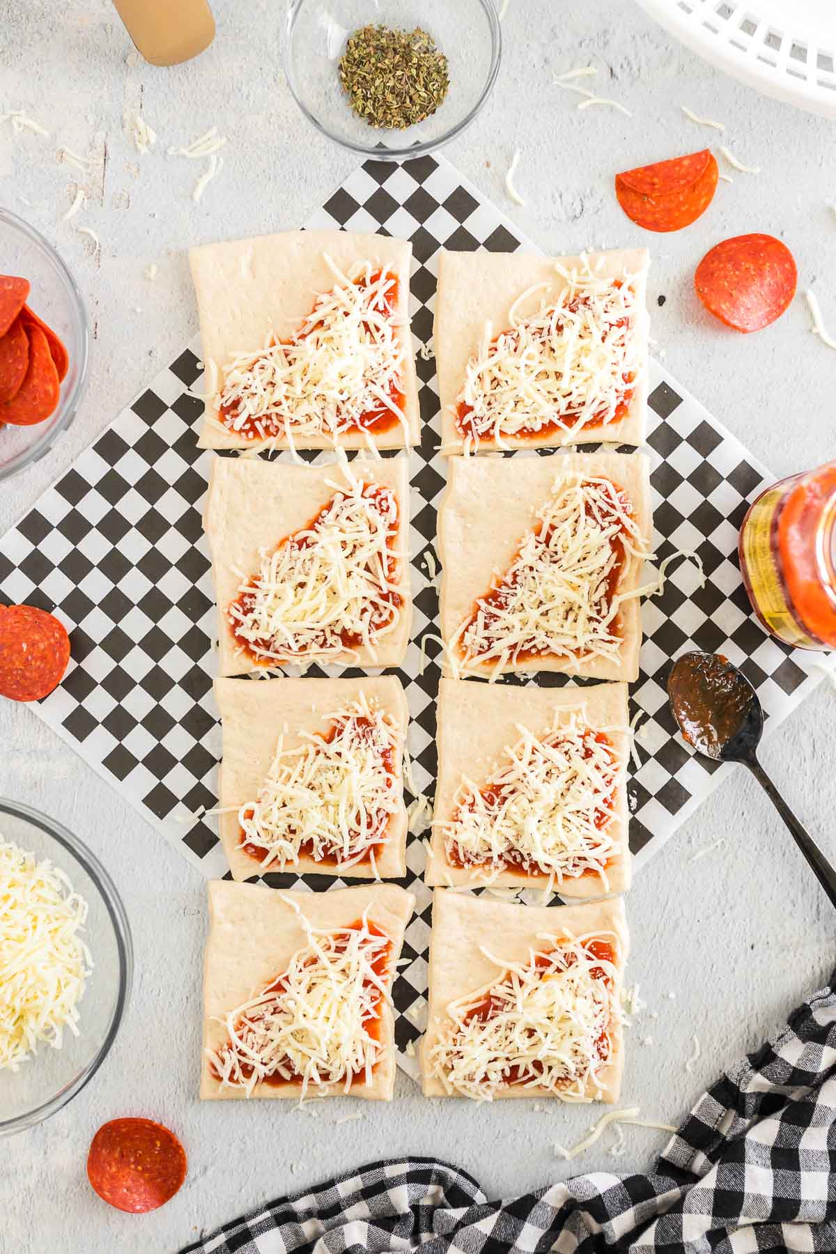 Mozzarella cheese placed over sauce on pizza crust.