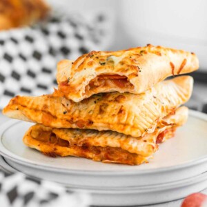 Stack of pepperoni pizza hot pockets on a plate.