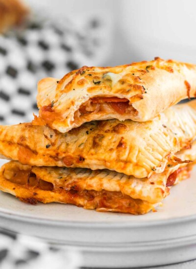 Stack of pepperoni pizza hot pockets on a plate.
