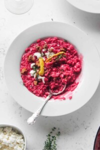 Bowl of pink valentine's day beetroot risotto with a spoon.