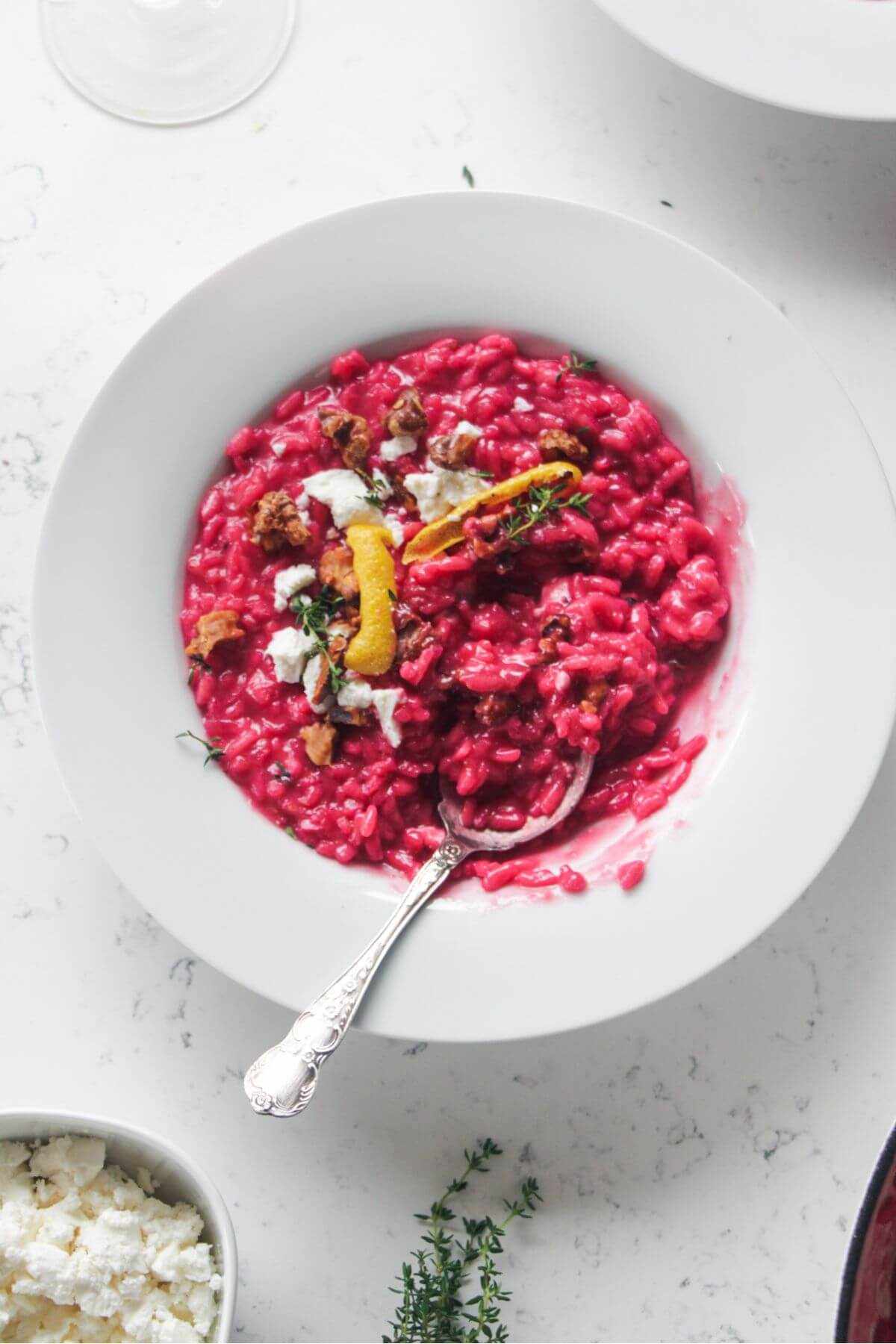 Bowl of pink valentine's day beetroot risotto with a spoon.