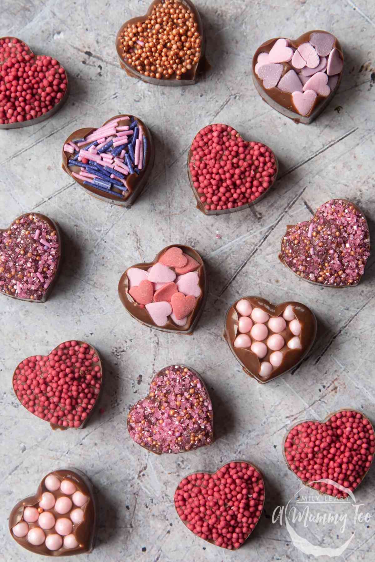 Heart shaped chocolate candies covered in sprinkles.