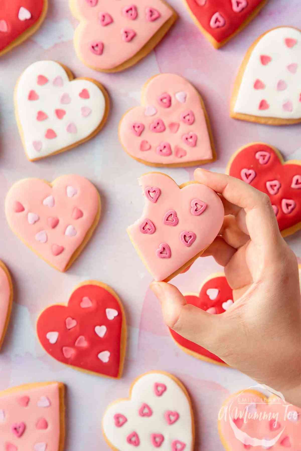 Pink, white and red heart shaped sugar cookies decorated with fondant and heart sprinkles.