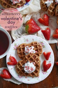 Plate full of heart shaped waffles and heart shaped strawberries.